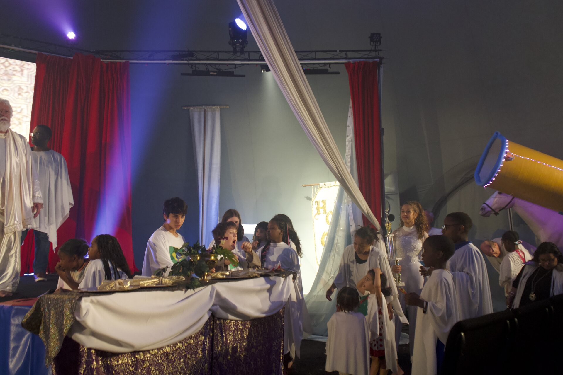 Children gathered around a table scene during The Greatest Show of All