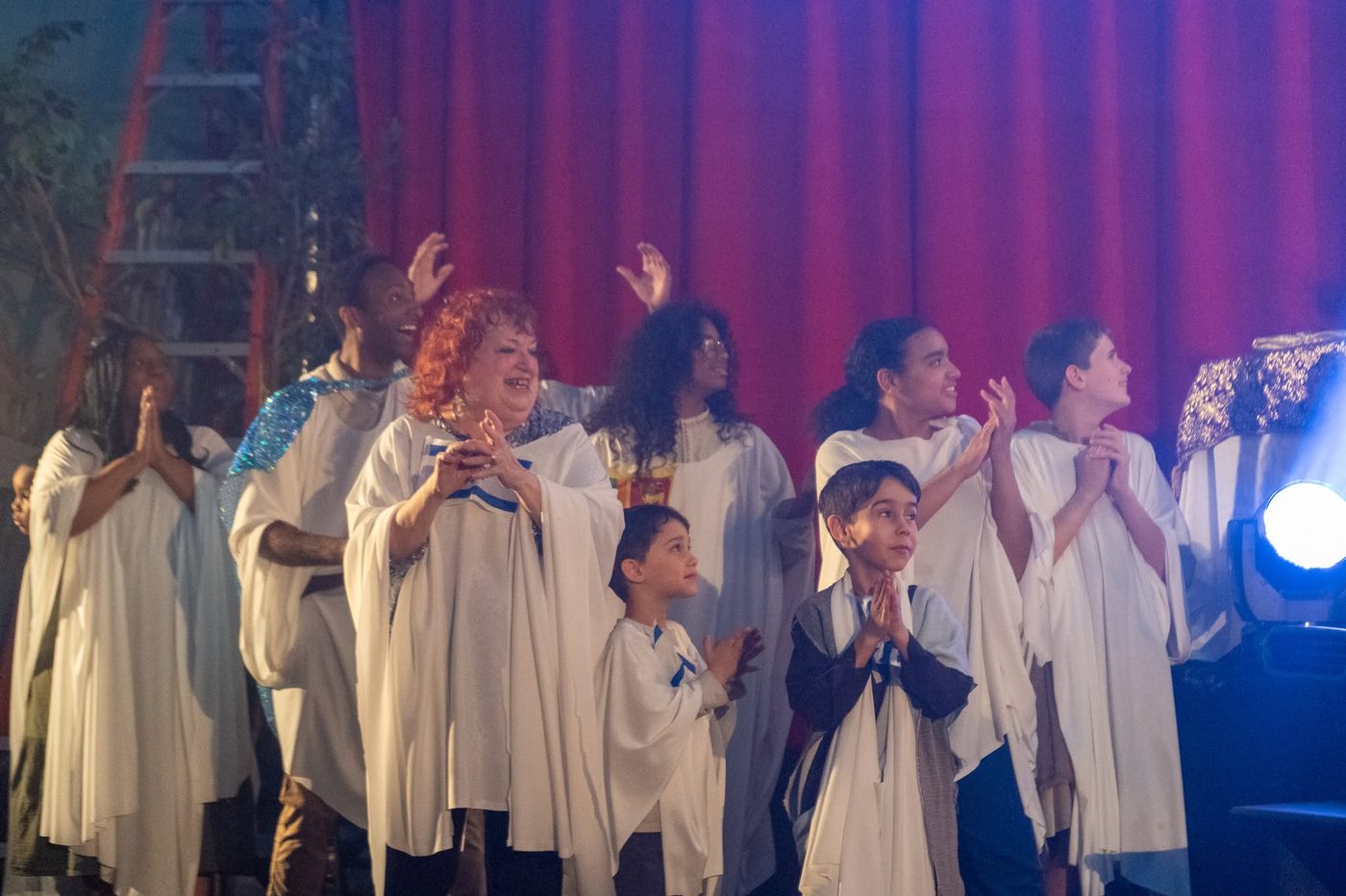 Families and church members in robes cheering together on stage