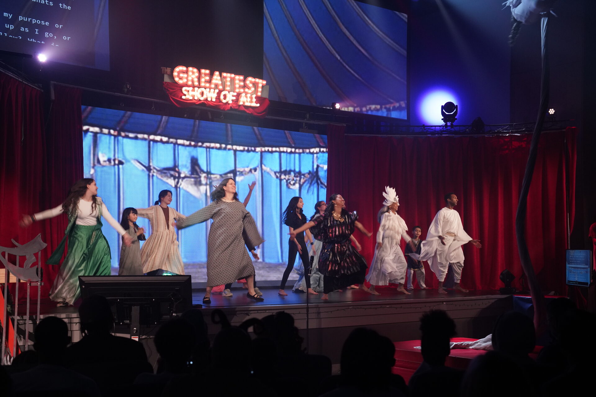 The full cast beneath The Greatest Show of All marquee