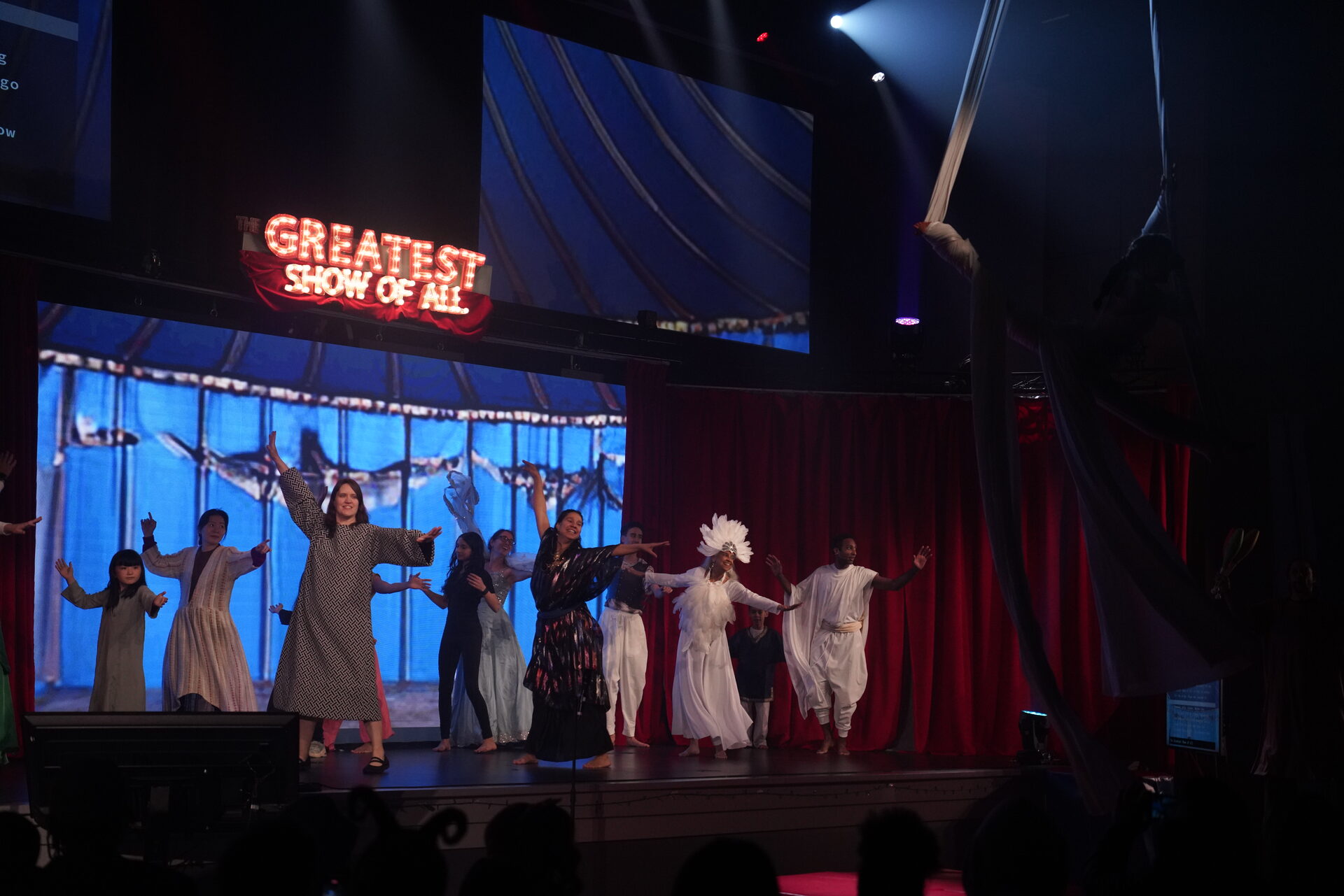 The full cast reaching toward the audience
